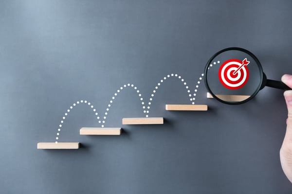 Dotted line jumping up four steps to reach a goal